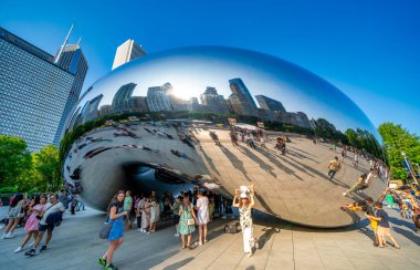 Chicago, IL - 26 Temmuz 2024: İnsanlar Millennium Park 'taki Bulut Kapısı boyunca bir yaz öğleden sonrasının keyfini çıkarıyorlar.
