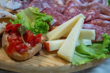 Geleneksel İtalyan şarküteri ve peynir tahtası taze ekmek ve süslemelerle servis ediliyor..