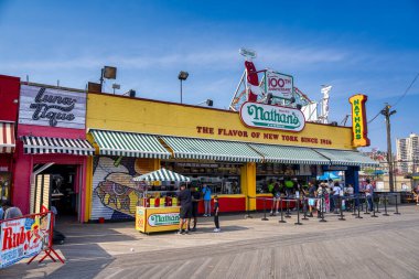 New York Şehri - 13 Haziran 2025: Nathan 'ın Coney Island eğlence alanında turistlerle olan ünlü dış görünüşünü gösteren şehir sahnesi.