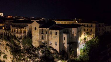 Gece Tropea 'nın ışıldayan binalar ve yaz mevsiminde karanlık denizlerle drone çekimi..