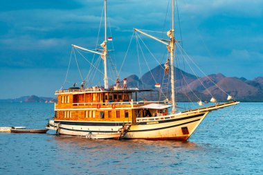 Güneş batarken etrafı tropikal renkler ve huzurlu denizlerle çevrili bir yolcu gemisinin manzarası..