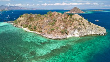 Kristal berrak suları ve tropikal ada manzarasıyla Pulau Kelor Komodo 'nun insansız hava aracı görüntüsü.