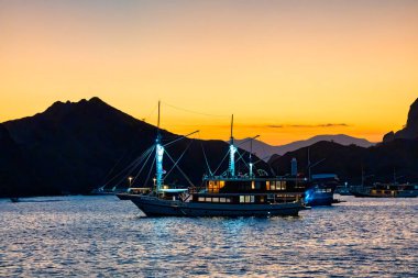 Komodo Körfezi 'nin sakin sularında dinlenen rahat bir yolcu teknesinin gece sahnesi..