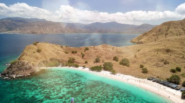 Komodo Pembe Kumsalı 'nın insansız hava aracı panoraması kristal berrak turkuaz suları ve tropikal kıyı şeridini gösteriyor..