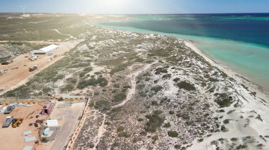 Coral Bay kıyı şeridinin insansız hava görüntüsü temiz mavi suları ve WA 'daki kumlu sahili gösteriyor..