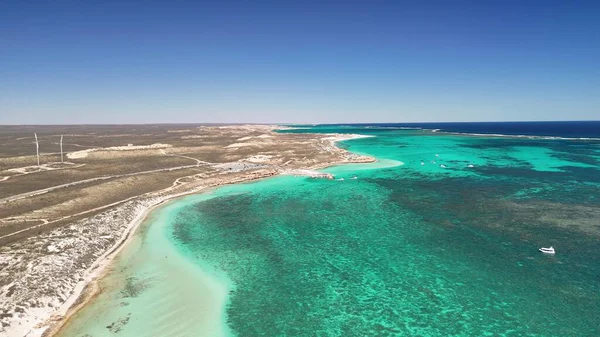 Coral Bay kıyı şeridinin insansız hava görüntüsü temiz mavi suları ve WA 'daki kumlu sahili gösteriyor..