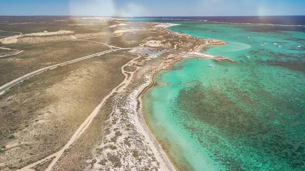 Coral Bay kıyı şeridinin insansız hava görüntüsü temiz mavi suları ve WA 'daki kumlu sahili gösteriyor..
