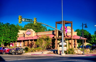 Moab, UT - 23 Haziran 2018: Moab Utah şehir merkezi gün batımında, arka planda renkli gökyüzü ve dağ siluetleri ile.