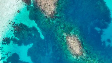 Komodo Ulusal Parkı 'ndaki el değmemiş sahil ve turkuaz deniz ile Pulau Karangan Adası' nın insansız hava aracı görüntüsü..