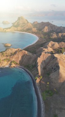 Mercan resiflerini ve el değmemiş doğal güzellikleri vurgulayan Komodo takımadalarının drone görüntüsü.