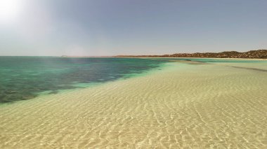 Coral Bay kıyı şeridinin insansız hava görüntüsü temiz mavi suları ve WA 'daki kumlu sahili gösteriyor..