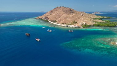 Pembe Plaj Komodo 'sunun yeşil tepeleri ve tropikal deniz manzarası..