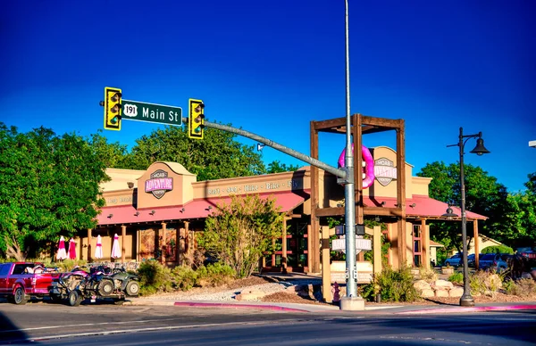 Moab, UT - 23 Haziran 2018: Moab Utah şehir merkezi gün batımında, arka planda renkli gökyüzü ve dağ siluetleri ile.