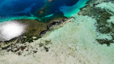 Mercan resifini ve açık tropikal denizi vurgulayan Pulau Karangan Komodo 'nun manzarası.