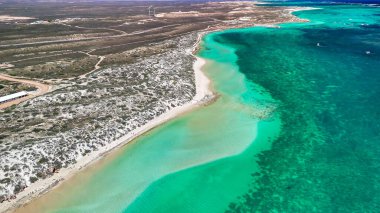 Coral Bay kıyı şeridinin insansız hava görüntüsü temiz mavi suları ve WA 'daki kumlu sahili gösteriyor..