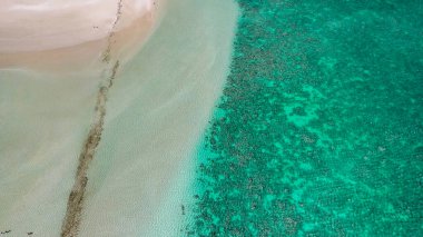 Coral Bay kıyı şeridinin insansız hava görüntüsü temiz mavi suları ve WA 'daki kumlu sahili gösteriyor..
