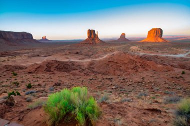 Anıt Vadisi 'nin engin çöl manzarası dramatik kum taşlarıyla sıcak güneş ışığıyla yıkandı..