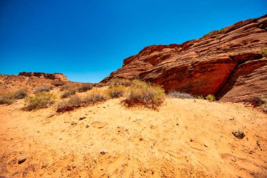 Kırmızı kum ve yontulmuş kaya duvarları aydınlatan ışık demetleriyle muhteşem Antilop Kanyonu iç mekanı.