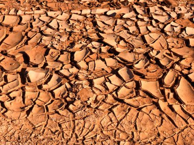 Anıt Vadisi 'ndeki kurumuş çöl zemininde güneş ışığı altında ikonik kaya oluşumlarıyla.