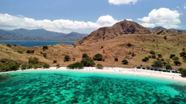 Komodo Pembe Kumsalı 'nın insansız hava aracı panoraması kristal berrak turkuaz suları ve tropikal kıyı şeridini gösteriyor..