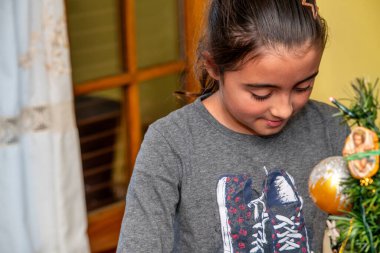 Son sınıftaki bayan Noel 'de güzel aydınlatılmış bir Noel ağacına süsler ekliyor..