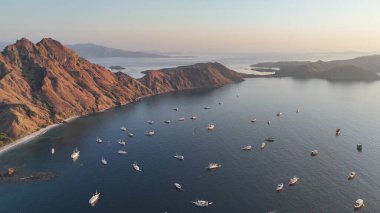 Mercan resiflerini ve el değmemiş doğal güzellikleri vurgulayan Komodo takımadalarının drone görüntüsü.