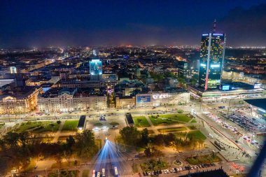 Parlayan sokaklar ve gökdelenlerle aydınlatılmış Varşova şehrinin hava gece görüşü.