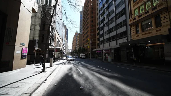 Merkez Sydney ana caddesi gün ışığında insanlar, araçlar ve dinamik hareketlerle yakalandı.