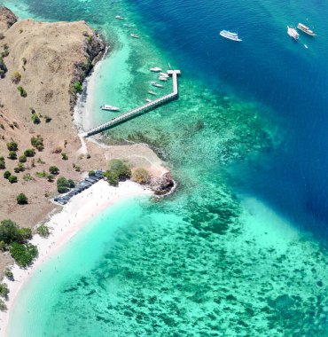 Komodo Ulusal Parkı 'ndaki Pembe Plaj' ın turkuaz tropikal sularla çevrili havadan panoramik manzarası..