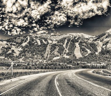 Jackson Village 'ın yaz mevsiminde yol ve dağlarla muhteşem manzarası, Wyoming..