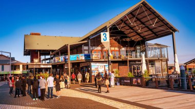 Perth, Avustralya - 31 Ağustos 2023: Turistler gün batımında nehir kenarında yürürler.