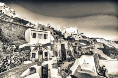 Santorini, Yunanistan - 11 Haziran 2014: Yunanistan 'ın Santorini kentinde Ege Denizi' ne tepeden bakan beyaz ve pastel renkli mimarinin çarpıcı kontrastı.