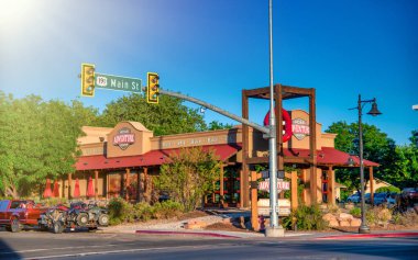 Moab, UT - 23 Haziran 2018: Moab Utah şehir merkezi gün batımında, arka planda renkli gökyüzü ve dağ siluetleri ile.