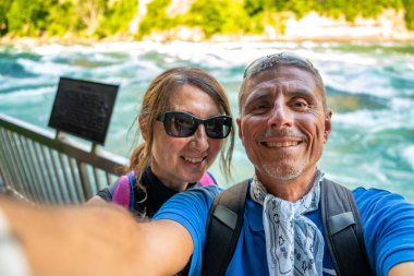 Niagara Şelalesi 'ni gezen gülen ortaklar etrafları akan su ve doğal manzaralarla çevrili..