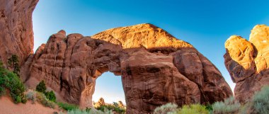 Arches Ulusal Parkı 'nın panoramik manzarası Utah' ın açık mavi yaz gökyüzü altında.