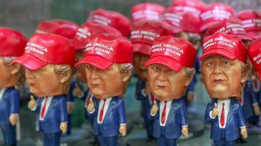 New York City, New York - 12 Haziran 2025: New York 'taki bir mağazada hatıra olarak sergilenen Trump kuklalarının ve temalı şapkaların çeşitliliği.