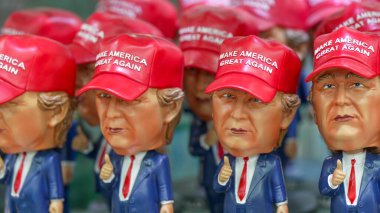 New York City, New York - 12 Haziran 2025: New York 'taki bir mağazada hatıra olarak sergilenen Trump kuklalarının ve temalı şapkaların çeşitliliği.