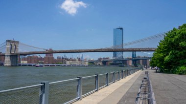 Brooklyn Köprüsü, New York 'taki sahil ve şehir manzaralı park perspektifinden görülüyor..