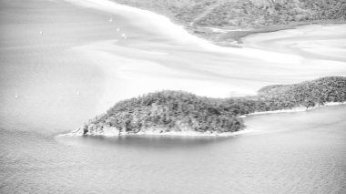 Queensland okyanusunun hava manzaralı perspektifi dalgaları, resifleri ve doğal kıyı şeridi şekillerini gösterir..