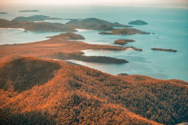 Queensland okyanusunun hava manzaralı perspektifi dalgaları, resifleri ve doğal kıyı şeridi şekillerini gösterir..