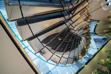 Modern binadaki parlak aynalı merdivenlerdeki ışık ve yansımaların soyut bileşimi.