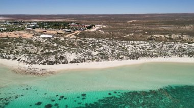 Coral Bay kıyı şeridinin insansız hava görüntüsü temiz mavi suları ve WA 'daki kumlu sahili gösteriyor..