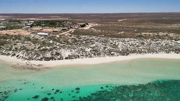 Coral Bay kıyı şeridinin insansız hava görüntüsü temiz mavi suları ve WA 'daki kumlu sahili gösteriyor..