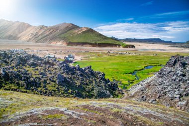 Landmannalaugar İzlanda 'da güneşli bir gün canlı bir manzara, dağlar ve vahşi doğa sergiliyor..