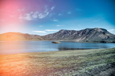 Landmannalaugar İzlanda 'da güneşli bir gün canlı bir manzara, dağlar ve vahşi doğa sergiliyor..