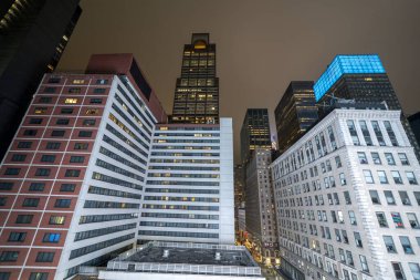 Midtown Manhattan 'ın gökdelenleri gece Broadway bölgesinde şehir ışıkları olan bir çatıdan görüldü..