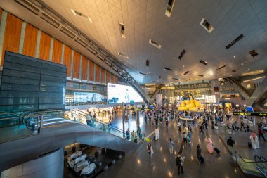 Doha, Katar - 14 Eylül 2025: Doha uluslararası havaalanı modern terminalinden geçen yolcular ve turistler.