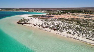 Coral Bay kıyı şeridinin insansız hava görüntüsü temiz mavi suları ve WA 'daki kumlu sahili gösteriyor..