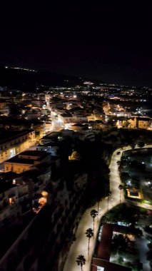 Gece Tropea 'nın ışıldayan binalar ve yaz mevsiminde karanlık denizlerle drone çekimi..