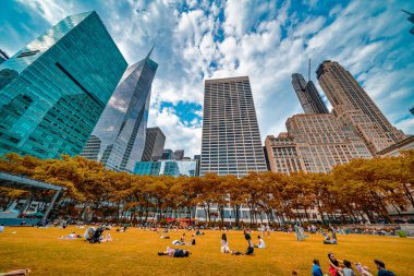New York City, New York - 12 Haziran 2025: Güneşli yaz günü Bryant Park 'ın çimlerinde dinlenen turistler ve yerel halk.